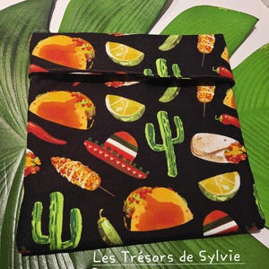 Peut inclure: Une pochette en tissu noir avec un motif répétitif de tacos colorés, quartiers de citron vert, cactus verts, piments rouges, épis de maïs et sombreros. La pochette a un bord supérieur replié et le texte Les Trésors de Sylvie imprimé en bas.