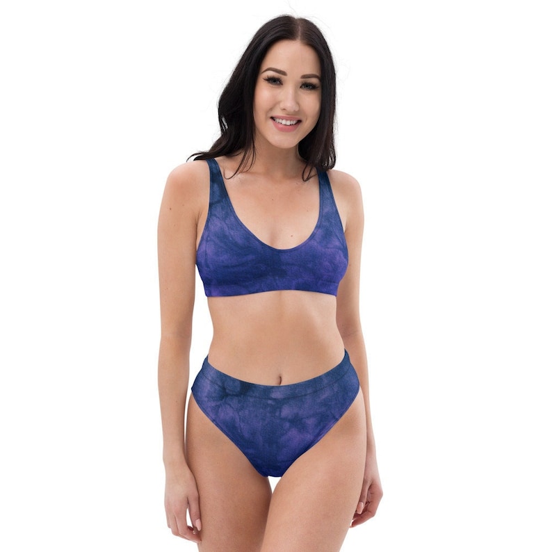 An eco-friendly bikini top with removable pattern. The color is a deep purple with hits of blue in a tie dye pattern.