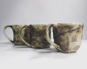 Intriguing green and brown tea cups /  coffee mugs, etched, in various glaze finishes in white stoneware