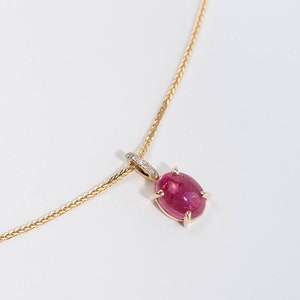 Solid gold pendant for women with a pink tourmaline prong set and diamonds on the bail.