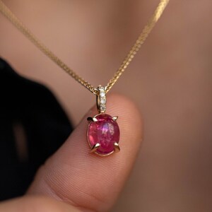 Natural gemstone pendant in 14K solid gold. The gemstones are an oval pink tourmaline a 5 clear brilliant diamonds.