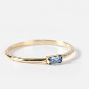 Natural blue sapphire baguette ring in 14K yellow gold in minimalist design.