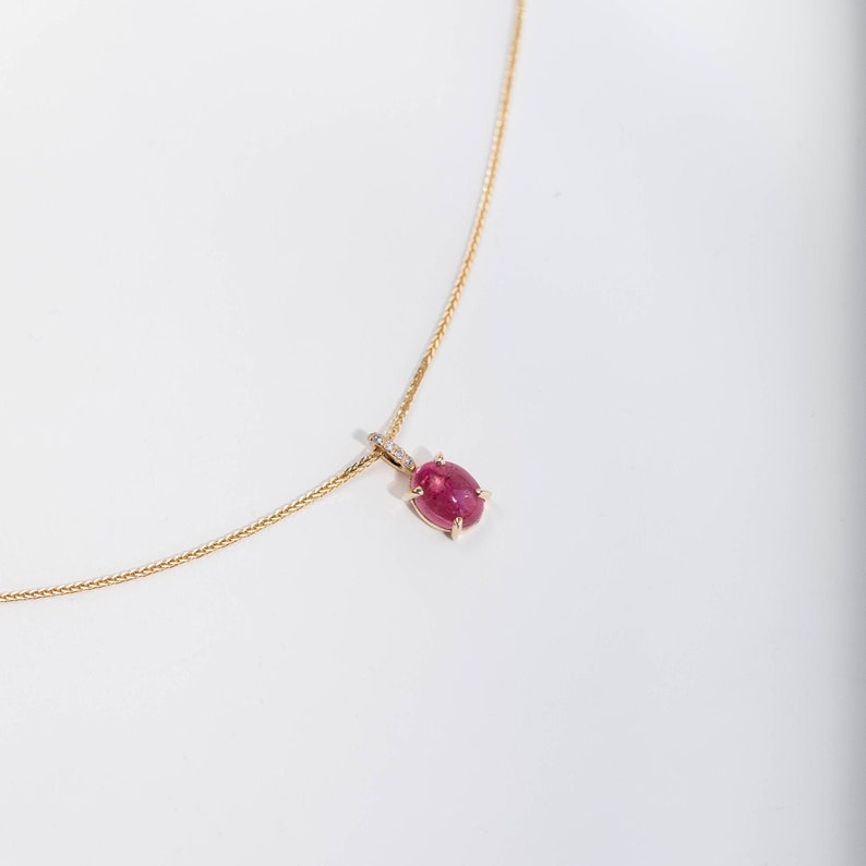 Solid gold pendant for women with a pink tourmaline prong set and diamonds on the bail.