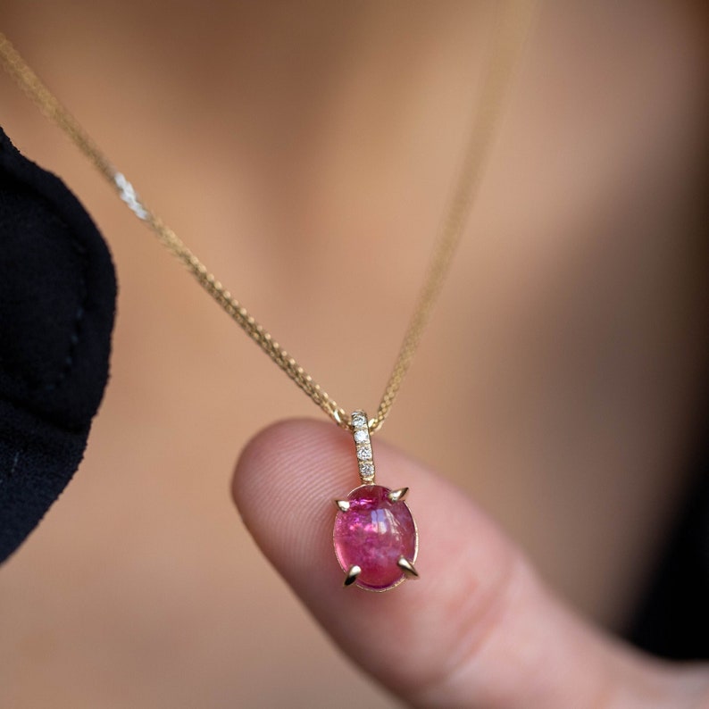 Pink tourmaline pendant necklace in 14K yellow gold. The ring on top of the pendant has five diamonds pave set that add extra glam.