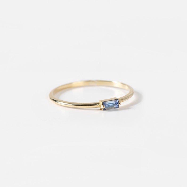 Natural blue sapphire baguette ring in 14K yellow gold in minimalist design.