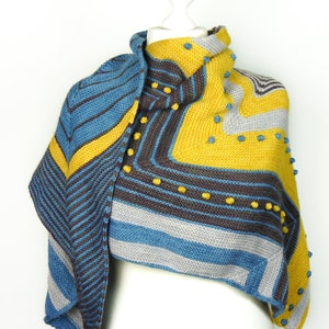 May include: A triangular knitted shawl in shades of blue, gray, yellow, and brown with a textured pattern and small yellow beads.