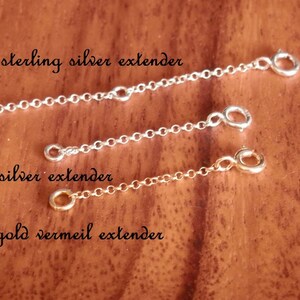 May include: Three chain extenders in sterling silver and gold vermeil. The longest is 5.08 cm, the other two are 2.54 cm each. The text on the image reads: "2" sterling silver extender", "1" s.silver extender", and "1" gold vermeil extender".