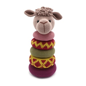 May include: A crocheted brown and pink llama toy with a stack of five colorful crocheted rings. The rings are red, yellow, green, and pink.