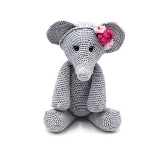 Może przedstawiać: Szara pluszowa zabawka słonia wykonana na szydełku z różowymi kwiatami na głowie. Słoń siedzi ze skrzyżowanymi nogami.