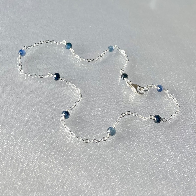 Peut inclure: Un bracelet de cheville en argent avec de petites perles de pierres pr&eacute;cieuses bleues.