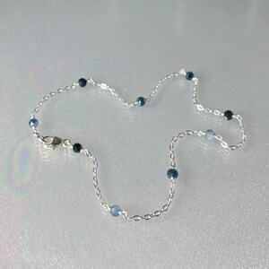 Peut inclure: Un bracelet de cheville en argent avec des perles de pierres pr&eacute;cieuses bleues.