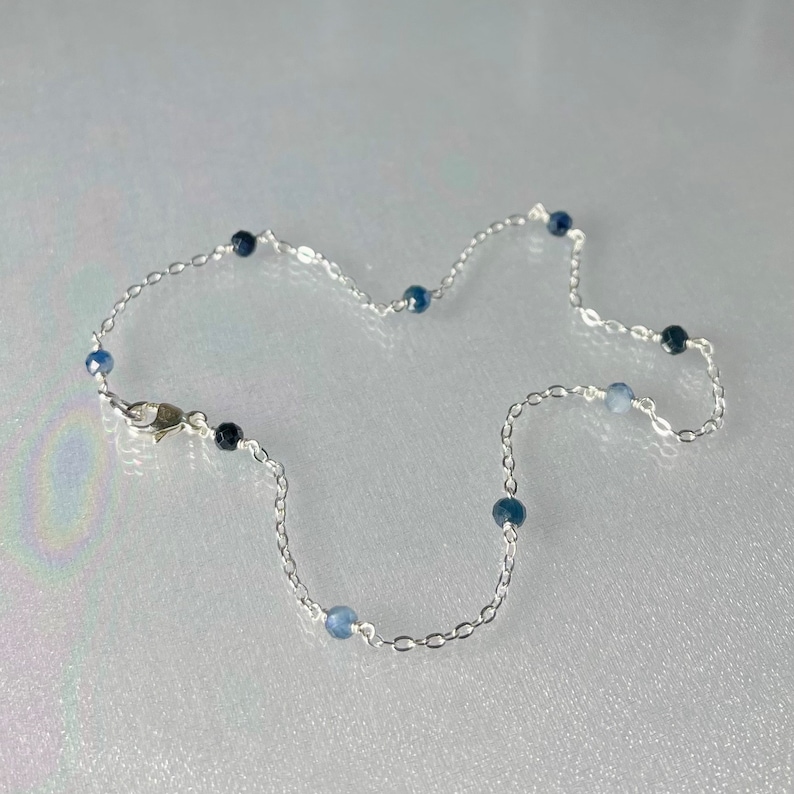 Peut inclure: Un bracelet de cheville en argent avec des perles de pierres pr&eacute;cieuses bleues.