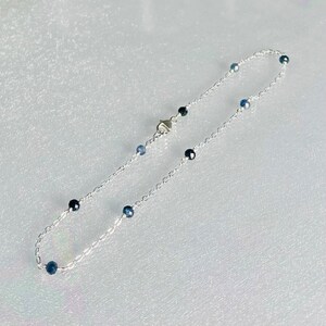 Peut inclure: Un bracelet de cheville en argent avec de petites perles de pierres pr&eacute;cieuses bleues.