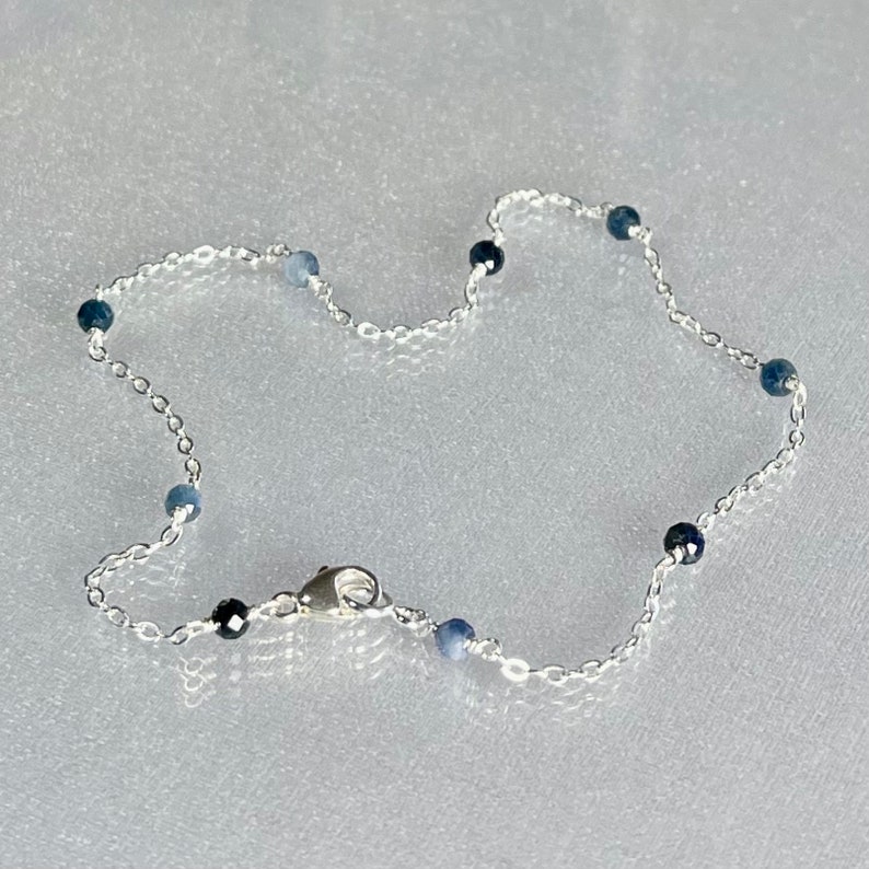 Peut inclure: Un bracelet de cheville en argent avec des perles de pierres pr&eacute;cieuses bleues.