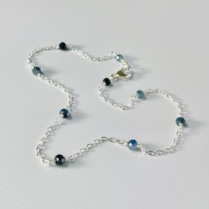 Peut inclure: Un bracelet de cheville en argent avec des perles de pierres pr&eacute;cieuses bleues. Le bracelet de cheville a un fermoir &agrave; ressort.