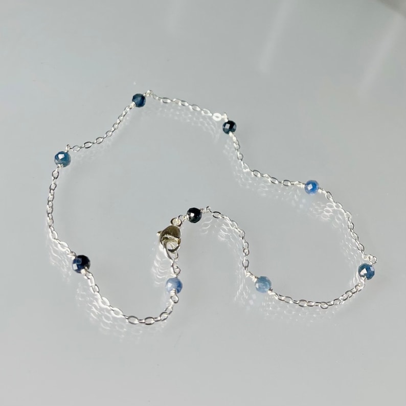Peut inclure: Un bracelet de cheville en argent avec des perles de pierres pr&eacute;cieuses bleues.