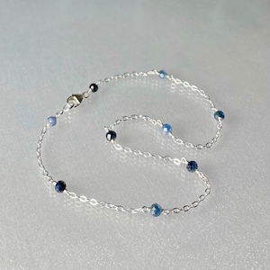 Peut inclure: Un bracelet de cheville en argent avec des perles de pierres pr&eacute;cieuses bleues.