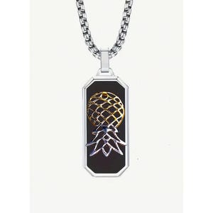 May include: A silver chain necklace with a black rectangular pendant featuring a gold and silver pineapple design.