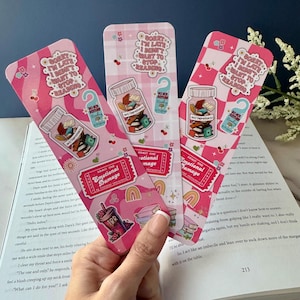 May include: Three pink and white bookmark designs with a checkered pattern. Each bookmark features a sticker of a jar filled with books and the text "Anti Depressants". One bookmark also features a sticker of a ticket that says "Admit One Emotional Damage by Fictional Characters". The text on the bookmarks reads "Sorry I'm Late I Don't Want to Stop Reading".