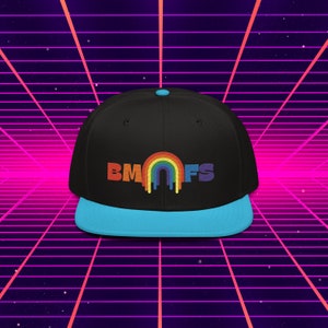 Peut inclure: Une casquette de baseball noire et bleue avec un arc-en-ciel et le texte "BMNFS" en noir.