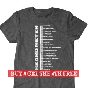 May include: A dark gray t-shirt with a white graphic of a beard measuring scale. The scale is labeled with different beard lengths and descriptions, such as "Manly", "Cave Manly", "Sea Captainly", and "Godly". The text "BUY 3 GET THE 4TH FREE" is printed in red at the bottom of the graphic.