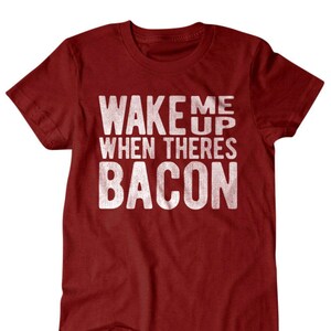 May include: Red t-shirt with white text that reads "Wake me up when there's bacon".