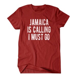 Pu&ograve; includere: Maglietta rossa con testo bianco che dice "Jamaica is calling I must go".