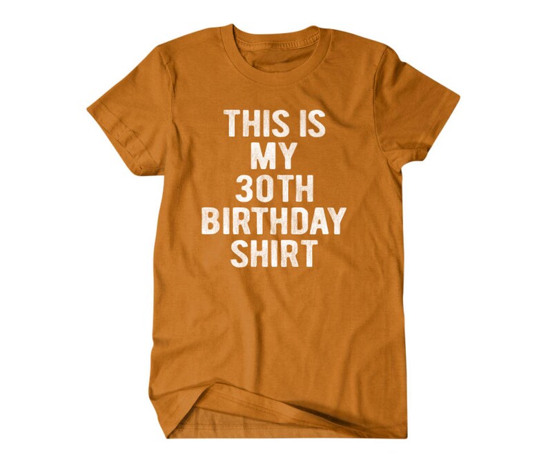 Puede incluir: Una camiseta amarilla mostaza con el texto "This is my 30th Birthday Shirt" en blanco.