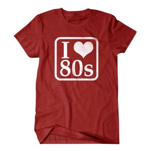 May include: Red t-shirt with a white square graphic that says "I love 80s" with a heart in place of the "O".