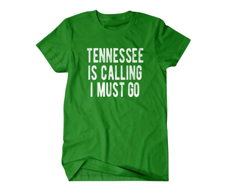 May include: Green t-shirt with white text that reads "Tennessee is calling I must go."