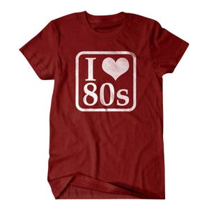 May include: Red t-shirt with a white square graphic that says "I love 80s" with a heart in place of the "O".
