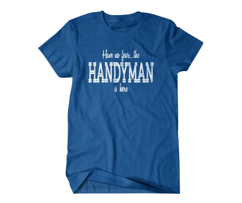 Op de afbeelding: Een koninklijk blauw t-shirt met witte tekst die "Have no fear... the HANDYMAN is here" luidt.
