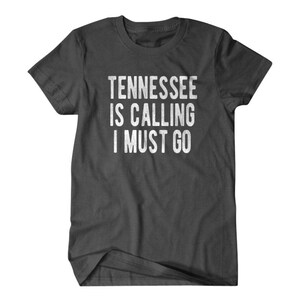 May include: A dark gray t-shirt with the text "Tennessee is calling I must go" printed in white.