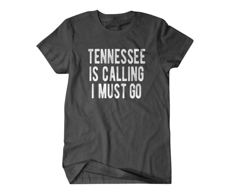 May include: A dark gray t-shirt with the text "Tennessee is calling I must go" printed in white.