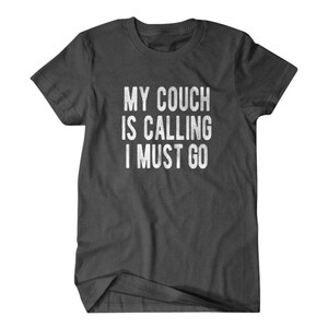 May include: Dark gray t-shirt with the text "My couch is calling I must go" printed in white.