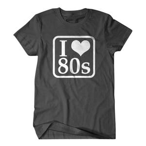 May include: A dark gray t-shirt with a white square graphic that says "I love 80s" with a heart in place of the "o".