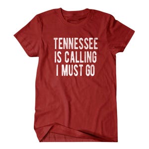 May include: Red t-shirt with white text that reads "Tennessee is calling I must go".