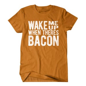 May include: A mustard yellow t-shirt with the text "Wake me up when there's bacon" printed in white.