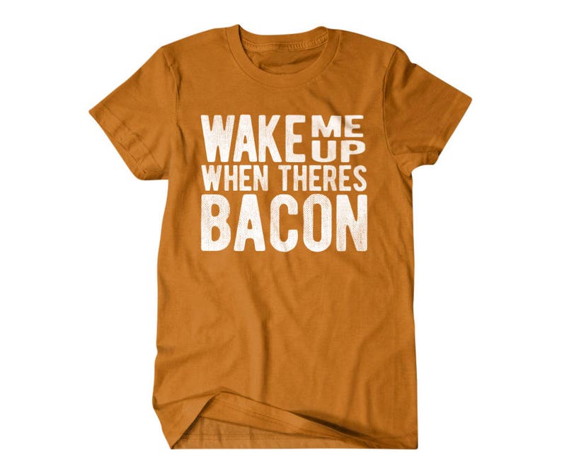 May include: A mustard yellow t-shirt with the text "Wake me up when there's bacon" printed in white.