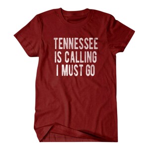 May include: Red t-shirt with white text that reads "Tennessee is calling I must go".
