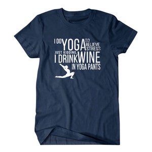 Puede incluir: Camiseta azul marino con texto blanco que dice "Hago yoga para aliviar el estr&eacute;s. Es broma, bebo vino con pantalones de yoga." Una silueta blanca de una persona en una pose de yoga est&aacute; en el centro del texto.