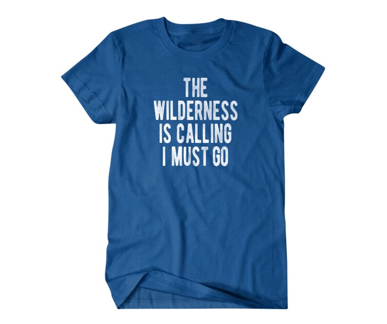 May include: A royal blue t-shirt with white text that reads "The Wilderness is Calling I Must Go".