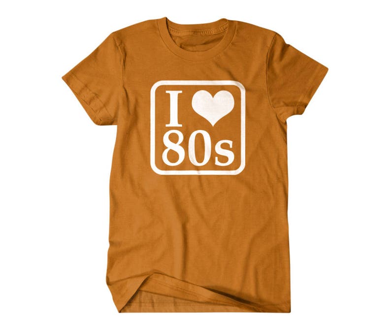 May include: A brown t-shirt with a white square graphic that says "I love 80s" with a heart in place of the "o".