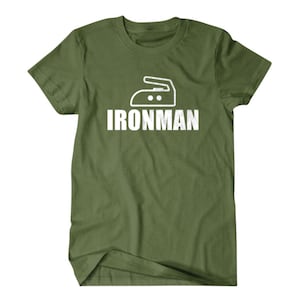 Puede incluir: Una camiseta verde con un gr&aacute;fico de plancha blanco y el texto "IRONMAN" impreso en la parte delantera.