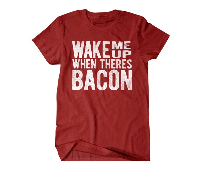 May include: Red t-shirt with white text that reads "Wake Me Up When There's Bacon".