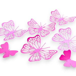 May include: A set of six pink butterfly wall decals. The butterflies are made of a thin, metallic material and have a delicate, lacy design.