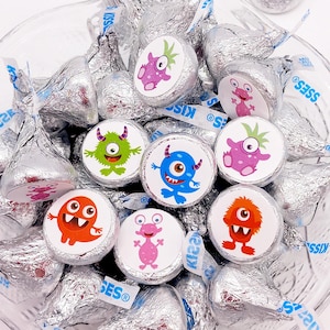 Round monster baby shower stickers sized to fit chocolate kisses, arranged on a matte sheet.