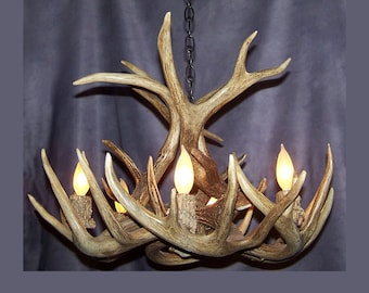 Può includere: Un lampadario rustico fatto di corna con quattro lampadine. Il lampadario è appeso a una catena e ha un colore marrone naturale.