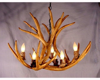 May include: A rustic chandelier made from antlers with six light bulbs. The chandelier is made from natural materials and has a unique, handcrafted look.