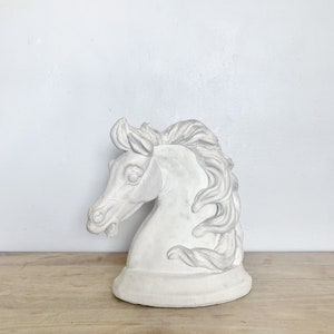 May include: White ceramic horse head sculpture. The horse has a flowing mane and a detailed face.